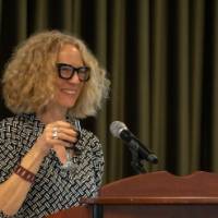 Provost Drake smiles holding her glass